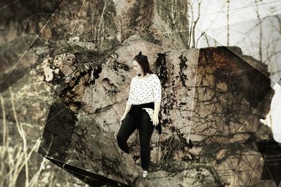 Woman standing by tree trunk