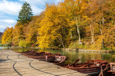 Wooden row boats by wooden pier on lake in plitvice lakes national park in croatia in autumn