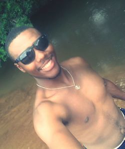 Portrait of smiling man wearing sunglasses at beach