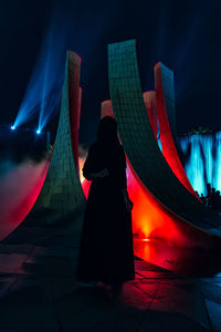 Silhouette woman standing against red illuminated structure