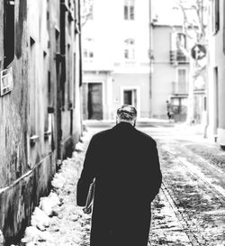 Rear view of man walking in snow