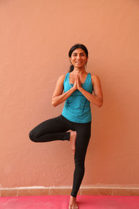 Portrait of happy young woman in a yoga standing pose