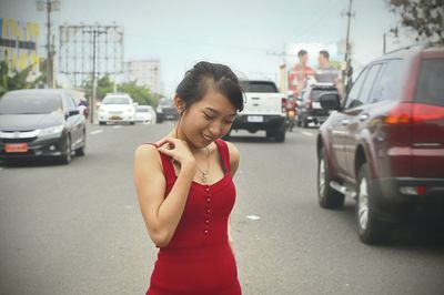 Young woman standing on road in city