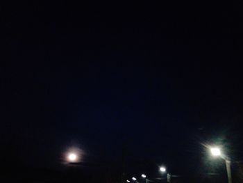 Low angle view of illuminated street light against sky