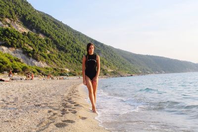 Full length of woman on beach against sky