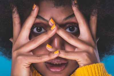 Close-up portrait of woman with hands gesturing over face