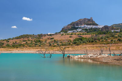 Scenic view of sea and mountains against blue sky