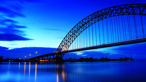 Bridge over river against sky at night