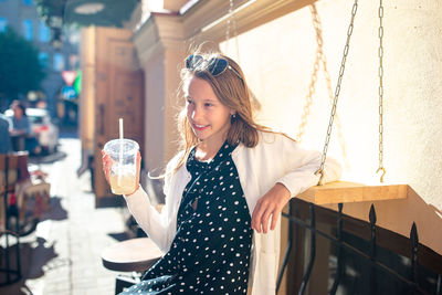 Portrait of a beautiful young woman drinking glass