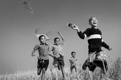 Children playing on field against sky