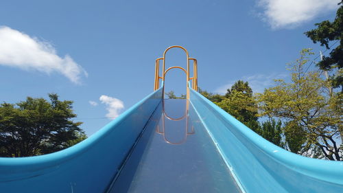 Low angle view of playground against blue sky