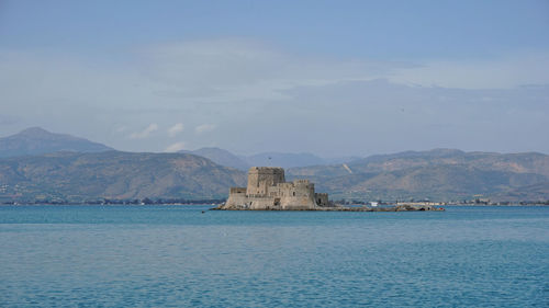 Scenic view of sea and mountains against sky