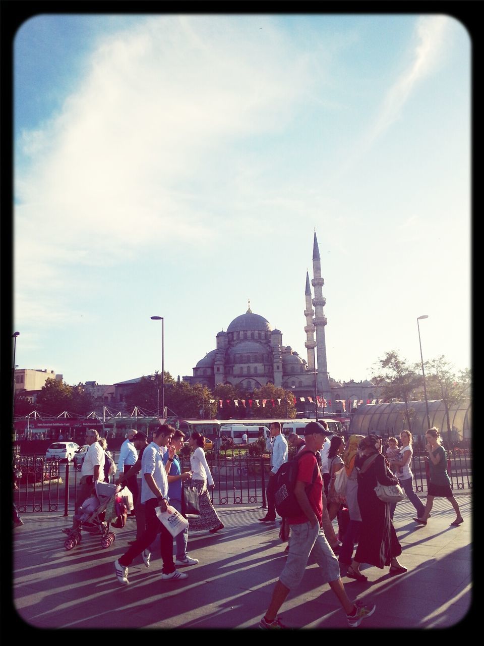 large group of people, transfer print, person, lifestyles, crowd, men, leisure activity, mixed age range, sky, auto post production filter, togetherness, enjoyment, building exterior, city life, architecture, built structure, street, city, cloud - sky