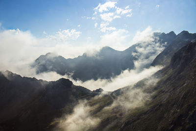 Scenic view of mountains with clouds against sky