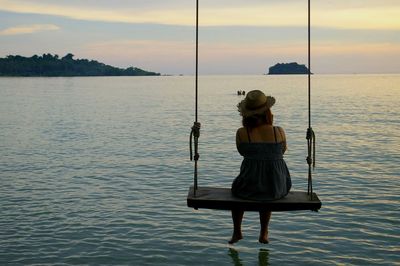 Man fishing in sea at sunset