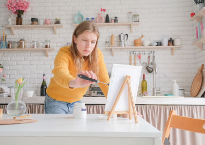 Portrait of young woman sitting on table