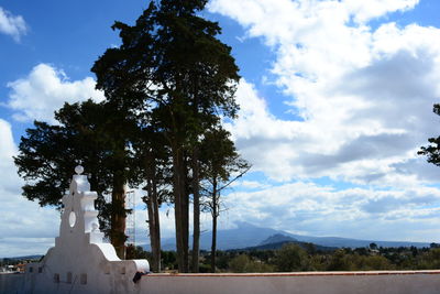 Statue amidst trees against sky