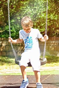 Full length of boy on swing in playground