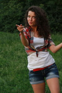 Woman pointing while walking on field
