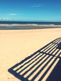 Scenic view of beach against blue sky