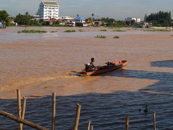 People in boat sailing on sea