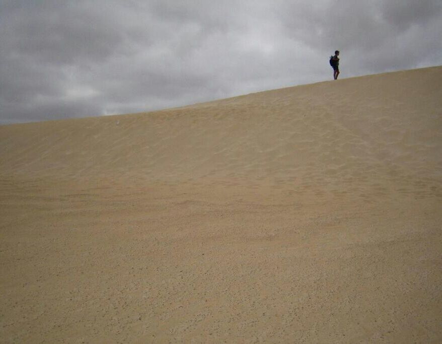 sky, cloud - sky, lifestyles, leisure activity, men, tranquil scene, tranquility, walking, standing, full length, sand, nature, landscape, scenics, cloudy, cloud, unrecognizable person, rear view