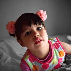 Close-up portrait of cute girl on bed at home