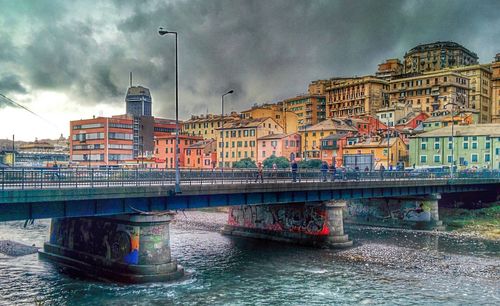 Bridge over river against cloudy sky