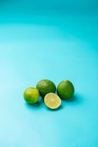 Limes photographed on a light blue background.