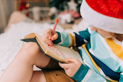 Midsection of girl drawing on book