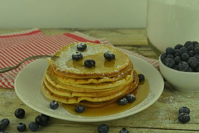 Pancakes with blueberries, maple syrup on a rustic white background