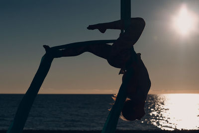 Silhouette man against sea during sunset