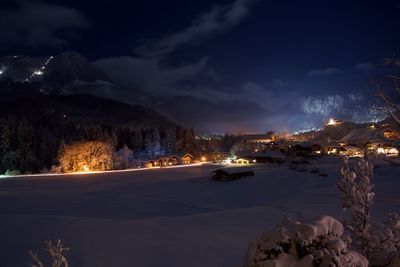 Illuminated city against sky at night during winter