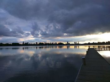 Pier on lake against cloudy sky