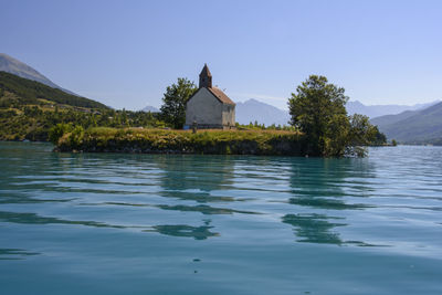 Scenic view of lake by building against sky