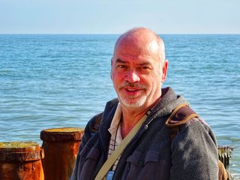 Portrait of smiling man standing at beach