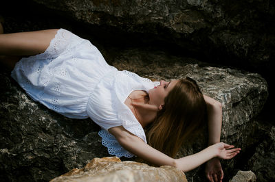 Young woman resting on rocks