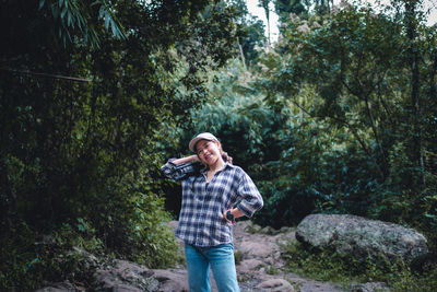 Young woman standing against trees