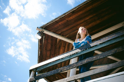 Low angle view of woman standing at observation point against sky