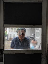 Portrait of man working in glass window