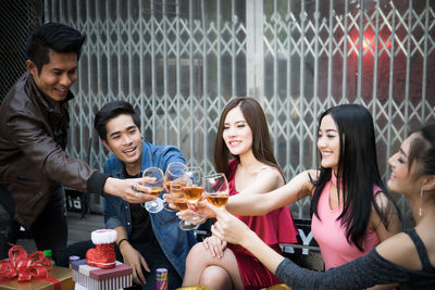 Friends toasting drinks during party