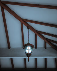 Low angle view of illuminated pendant light hanging from ceiling