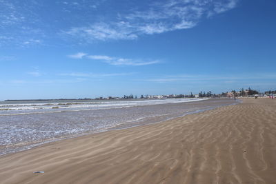 Scenic view of beach against blue sky