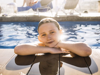 Portrait of smiling girl enjoying in swimming pool at resort