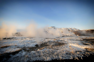 View of hot spring against sky during winter