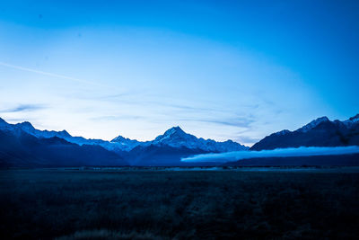 Scenic view of snowcapped mountains against blue sky