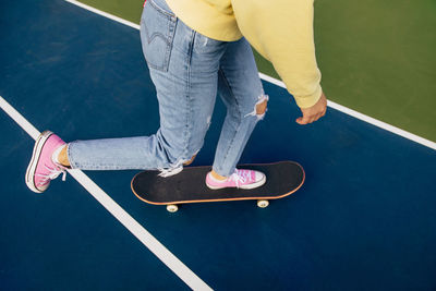 Low section of woman standing on skateboard