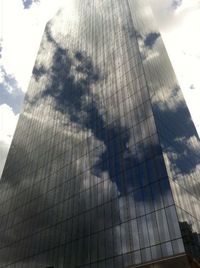 Low angle view of modern building against cloudy sky