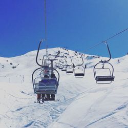 Ski lift hanging over snow covered mountains during winter