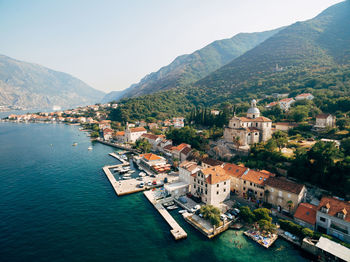 High angle view of townscape by sea against mountains